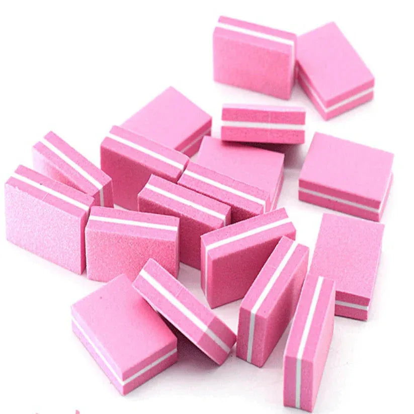 Pink nail sanding blocks with white stripes on a white background