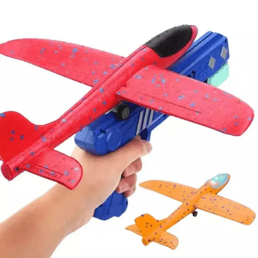 Red and blue toy airplane launcher with a small orange airplane attached, held by a hand.