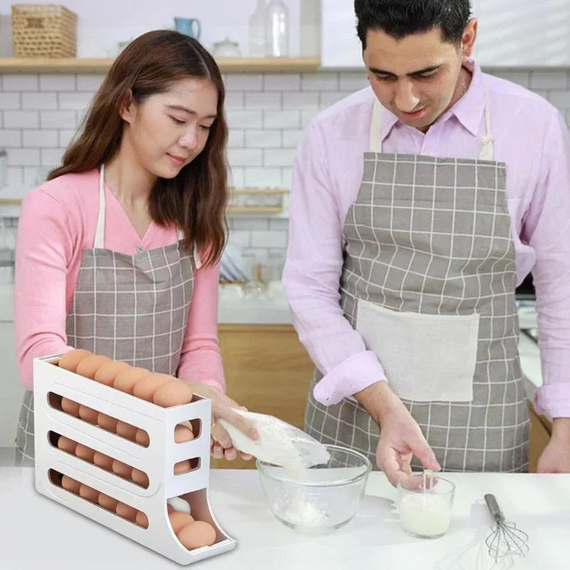 Two people in a kitchen preparing food, wearing aprons and using an egg holder.