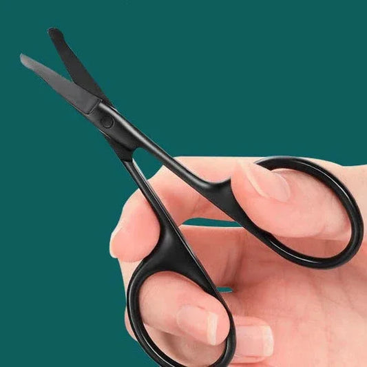 Black scissors held in a hand against a teal background