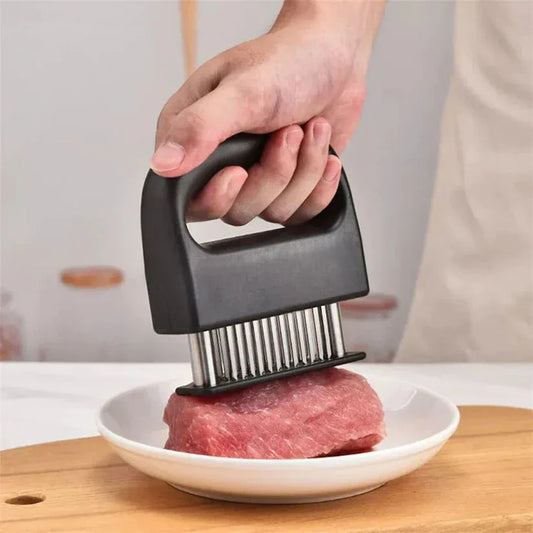Person using a meat tenderizer on a piece of meat on a white plate.