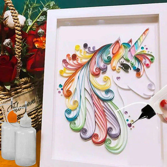 Colorful unicorn quilling art in a white frame with a hand holding a bottle of glue.
