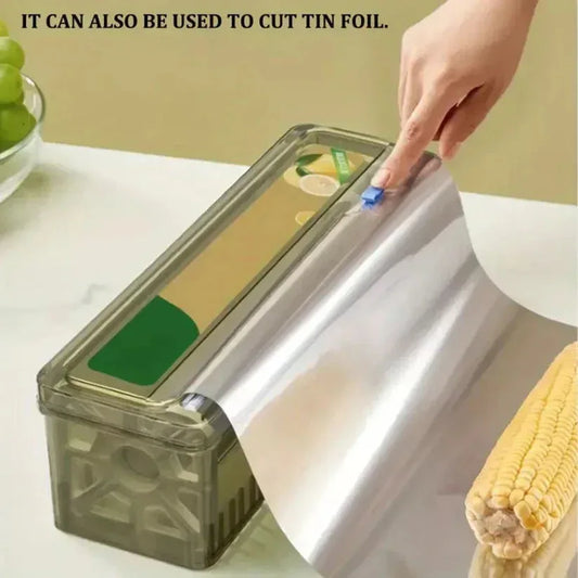 Roll of tin foil being cut with a kitchen tool on a countertop.