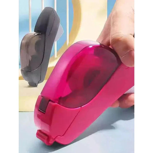 Pink and black office stapler held by a hand with a blurred background