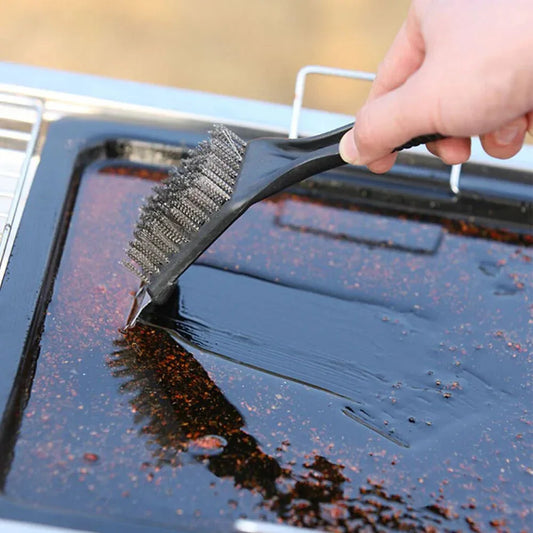 Person cleaning a grill with a brush