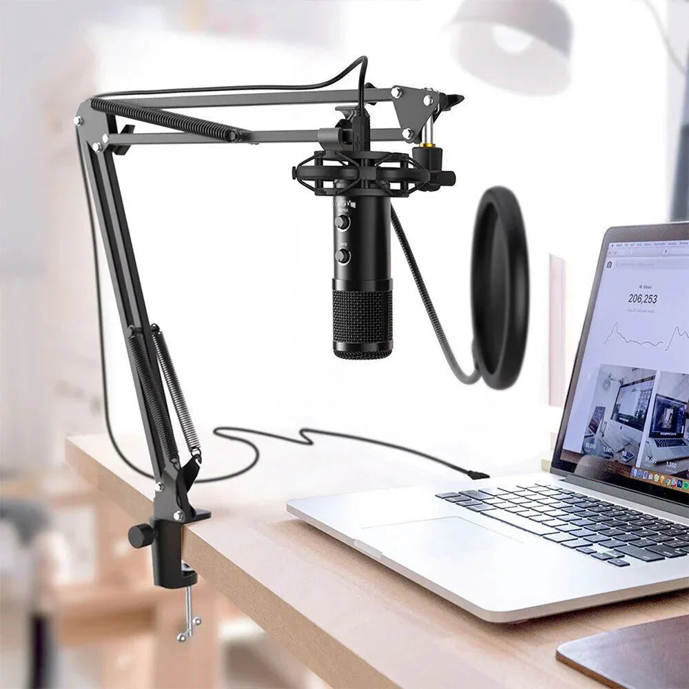 Microphone with stand and pop filter on a desk next to a laptop