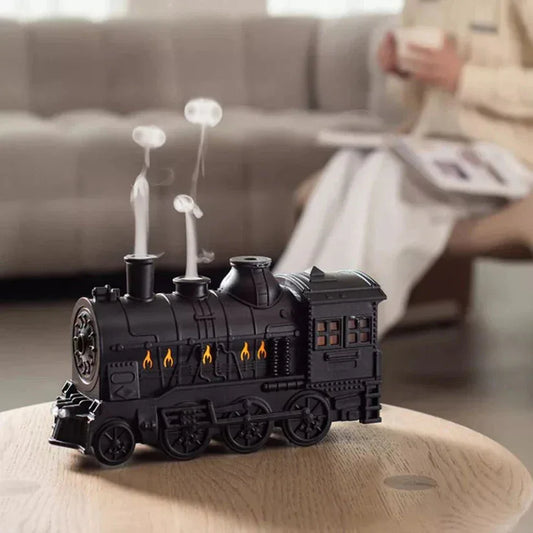 Black train-shaped candle on a table with a blurred background of a living room.