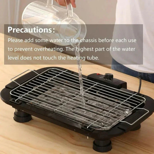 Electric grill with water being added to the chassis on a wooden surface, with text about precautions.