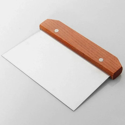 Spatula with wooden handle and white plastic blade on a light gray background