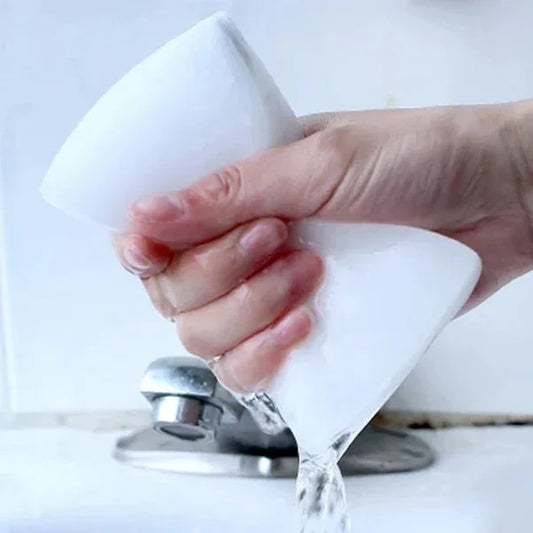 Hand holding a white funnel over a faucet with water flowing.