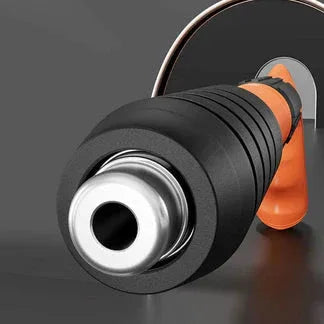 Close-up of a black and orange garden hose nozzle on a dark background

