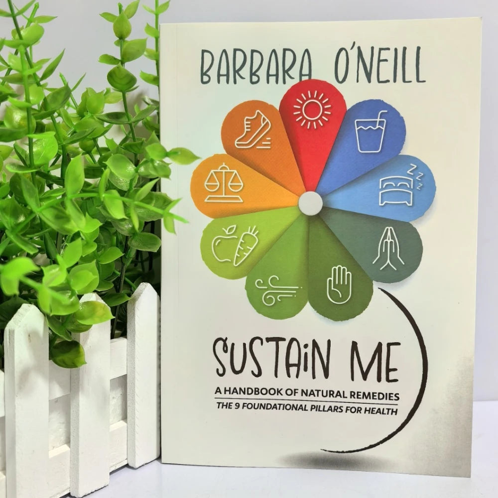 Book titled 'Sustain Me' by Barbara O'Neill with a colorful wheel design on the cover, placed next to a plant.

