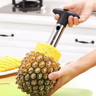 Person using a pineapple cutter to slice a pineapple

