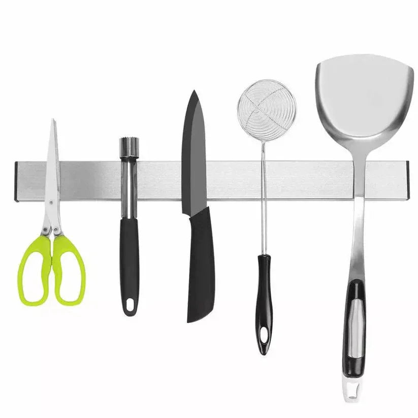 Set of kitchen utensils including scissors, knife, ladle, and spatula on a magnetic strip.

