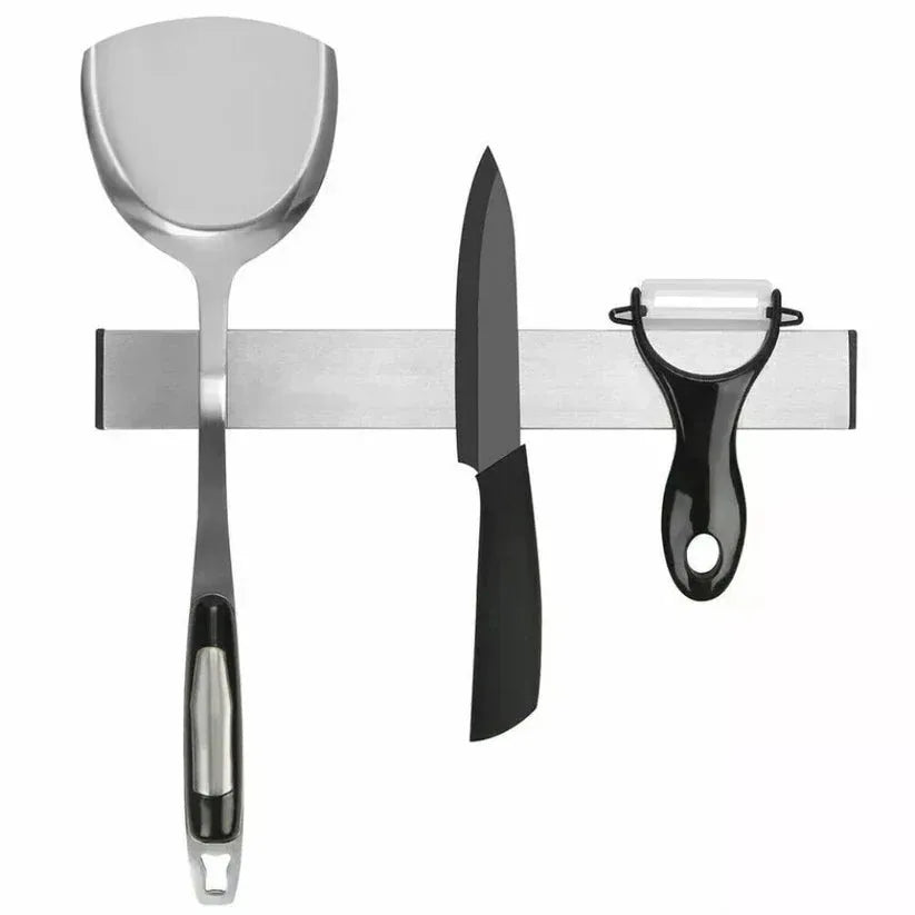 Set of kitchen utensils including a spatula, knife, and peeler on a magnetic strip.

