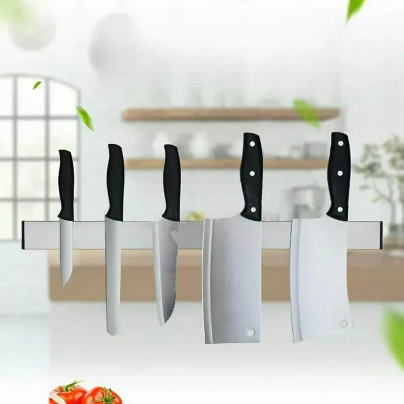 Set of knives on a magnetic knife holder with a kitchen background

