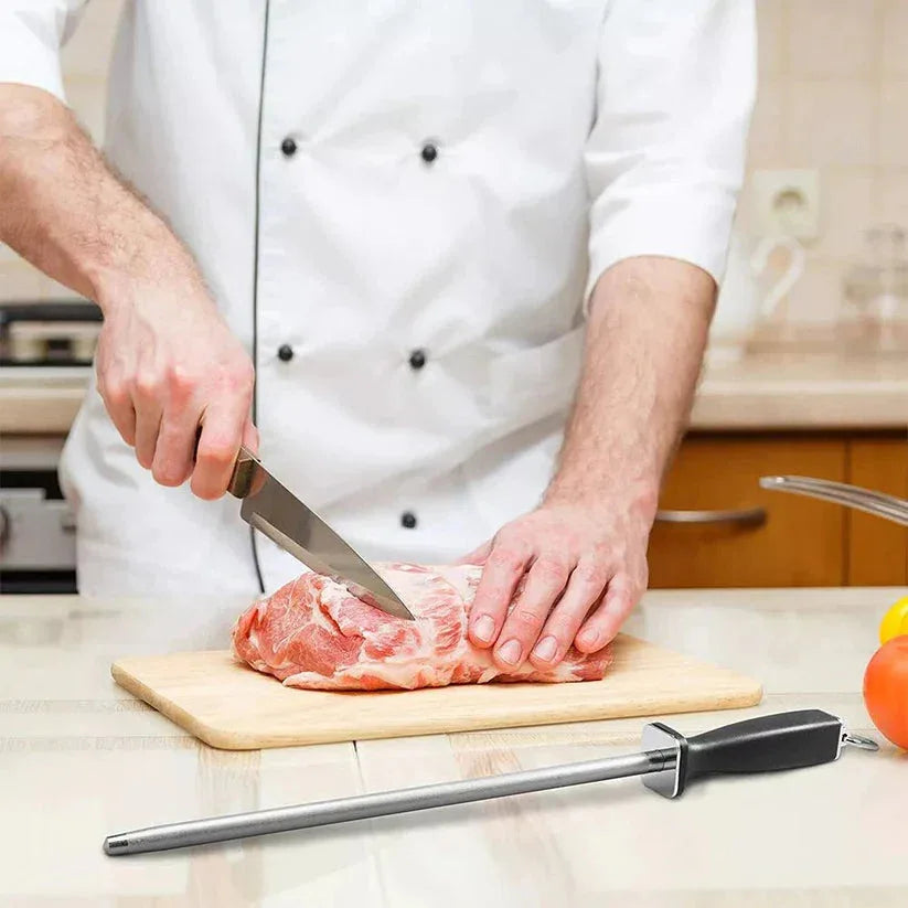 Person cutting meat on a wooden board with a knife in a kitchen setting

