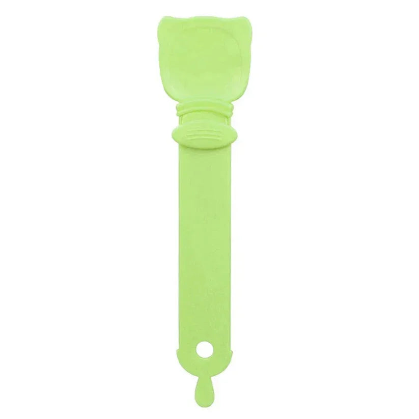 Green spatula with a textured head on a white background

