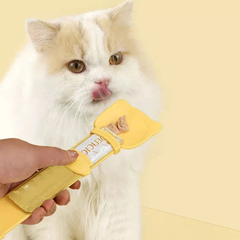 Cat being groomed with a yellow grooming tool on a light yellow background

