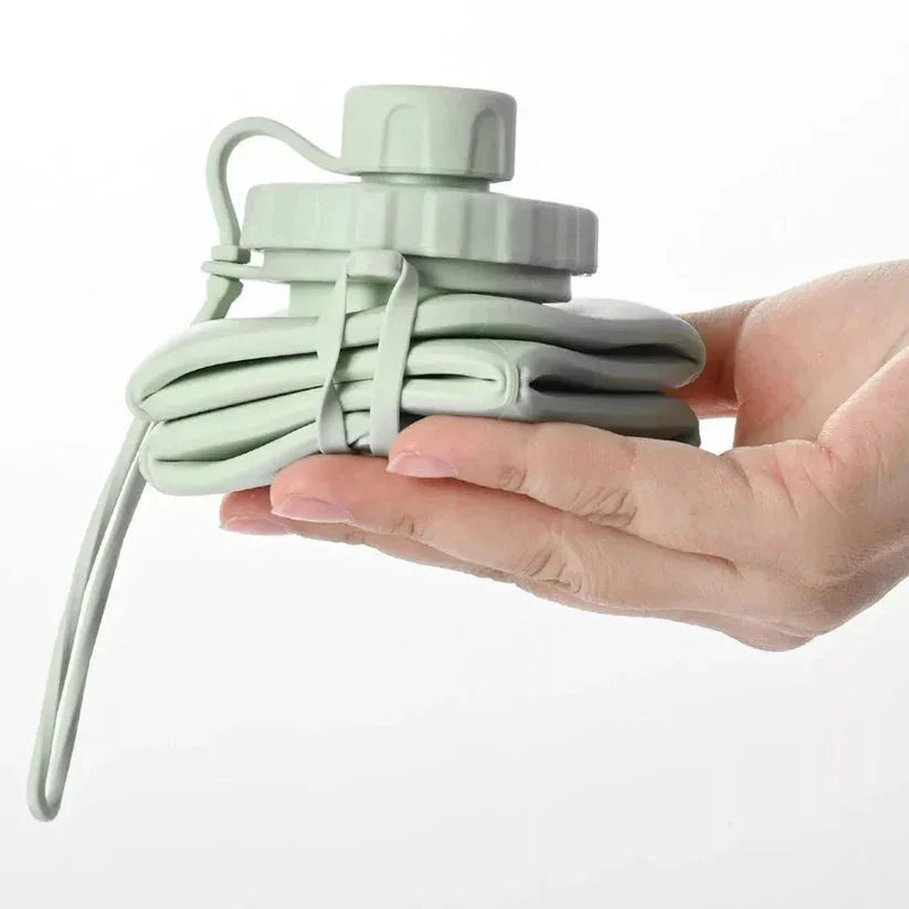 Light green cable organizer held in a hand against a white background

