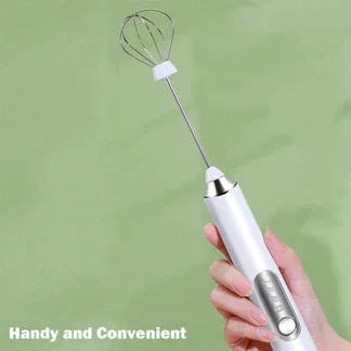 Handheld electric mixer with a whisk attachment held by a hand against a green background

