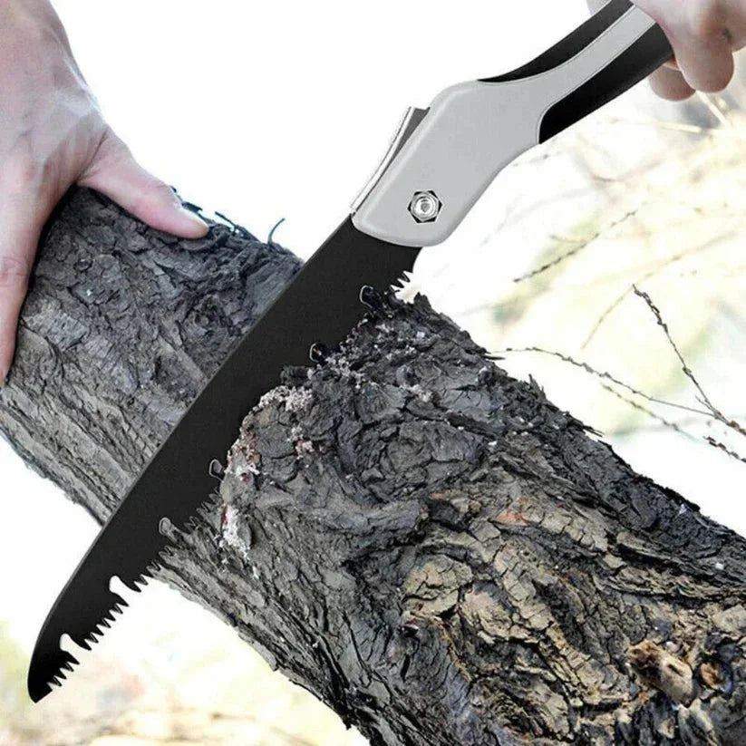 Person using a folding saw to cut through a log outdoors

