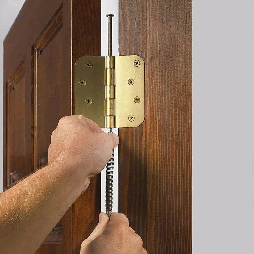 Hand opening a wooden door with a brass hinge.

