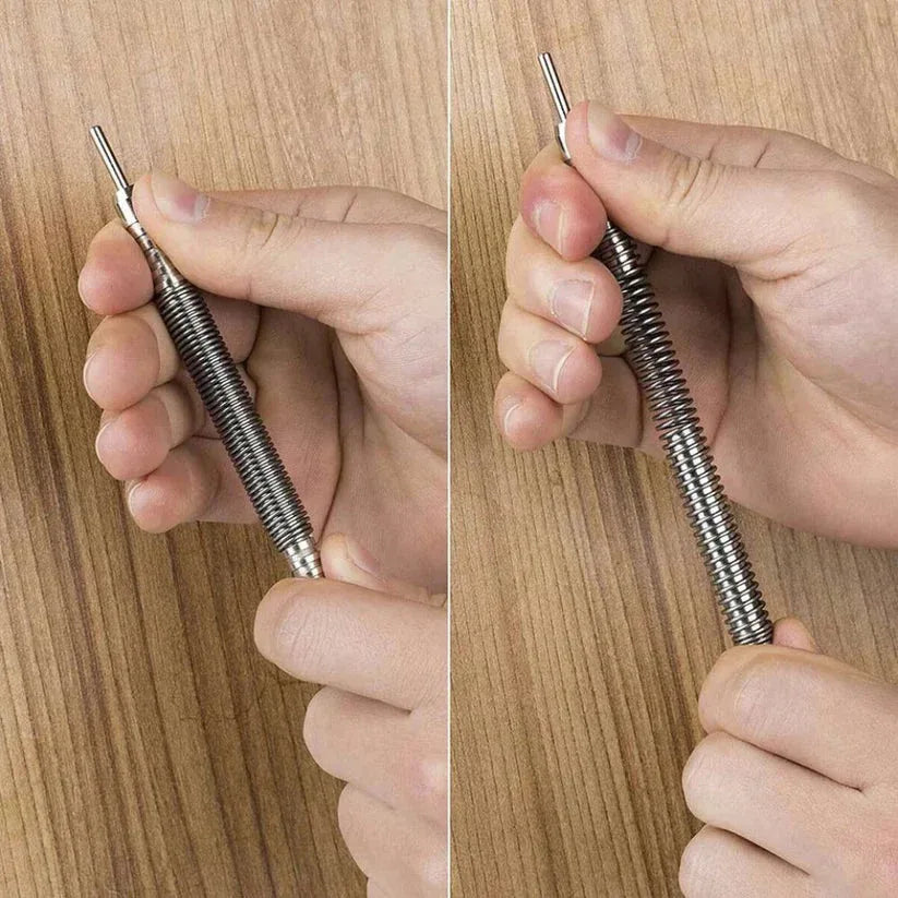 Metallic flexible straw being bent by a hand on a wooden surface

