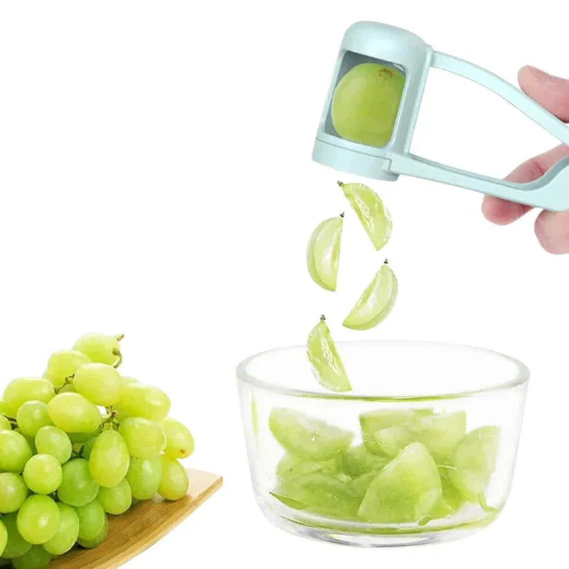 Grape peeler being used to remove skin from green grapes, with a bowl of peeled grapes on a white background.

