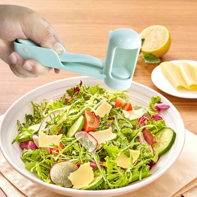 Hand using a salad spinner to prepare a salad on a wooden table.

