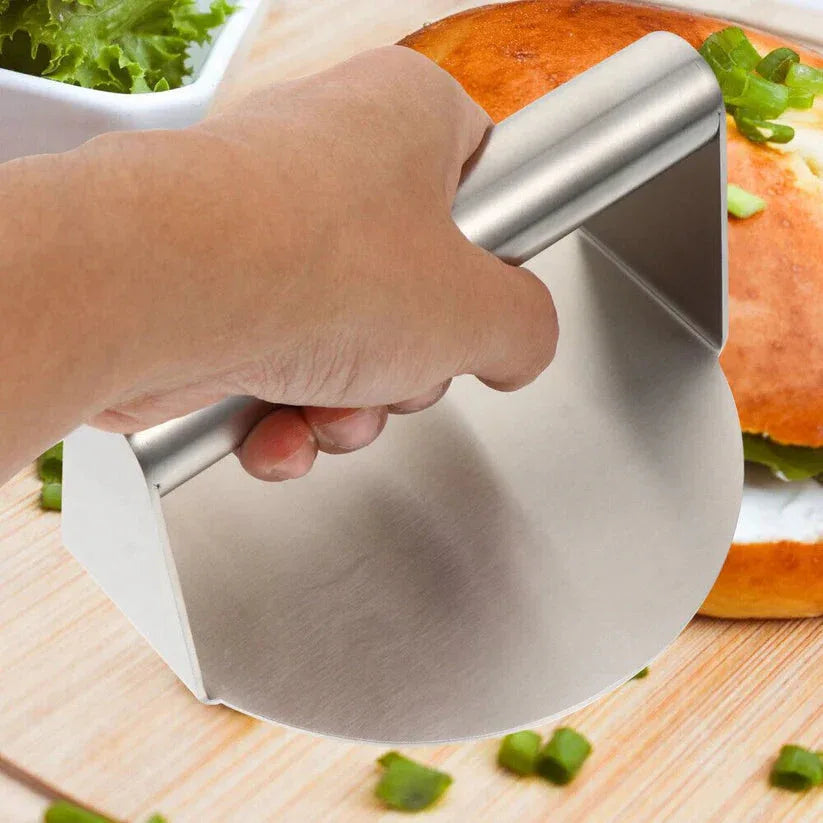 Hand using a pizza cutter on a pizza with a bowl of salad in the background


