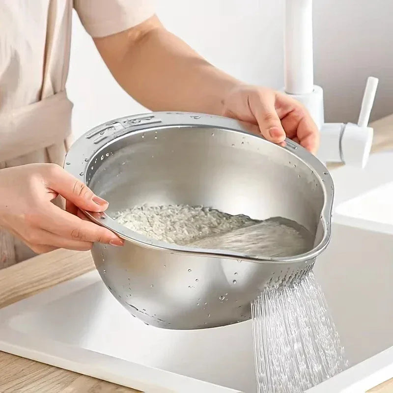 Person washing rice in a metal colander over a sink.

