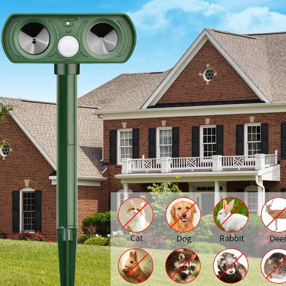 Deterrent device on a grassy lawn with a house in the background

