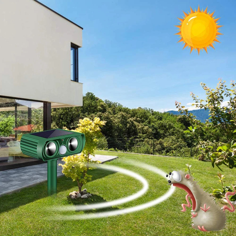 Solar-powered pest control device in a garden with a house and trees in the background.

