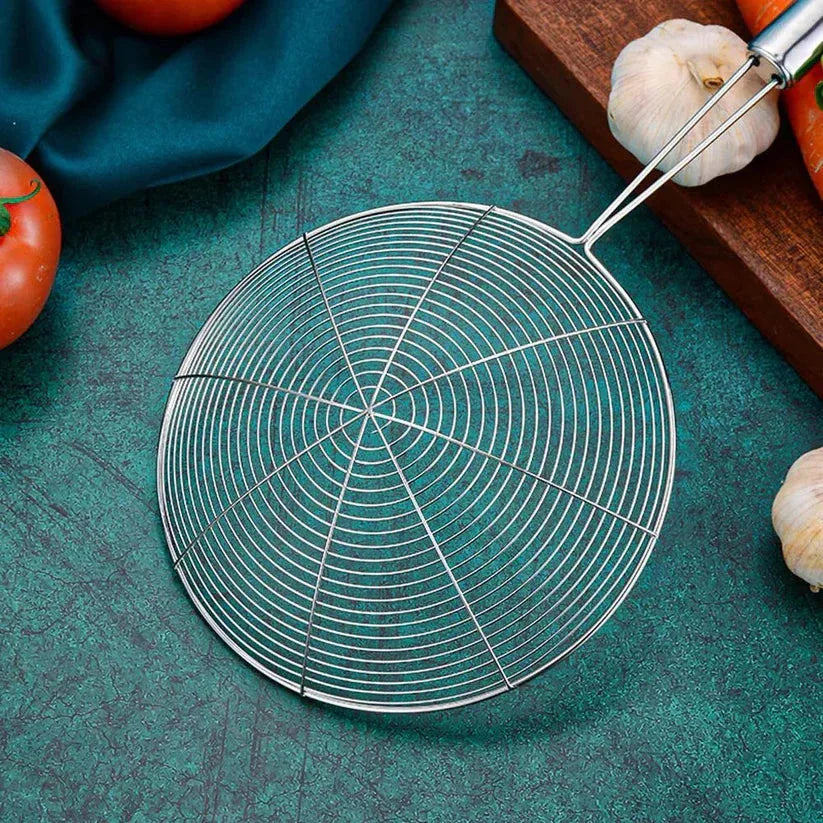 Metal strainer on a green surface with vegetables in the background

