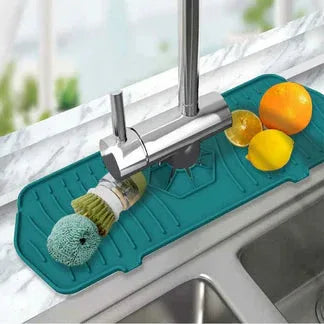 Teal sink mat with sponge and lemons on a kitchen sink

