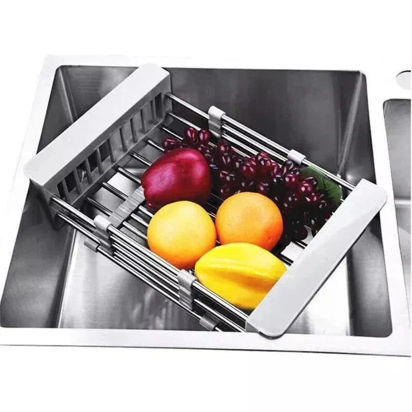 Stainless steel sink with a fruit and vegetable drainer containing fruits and vegetables.


