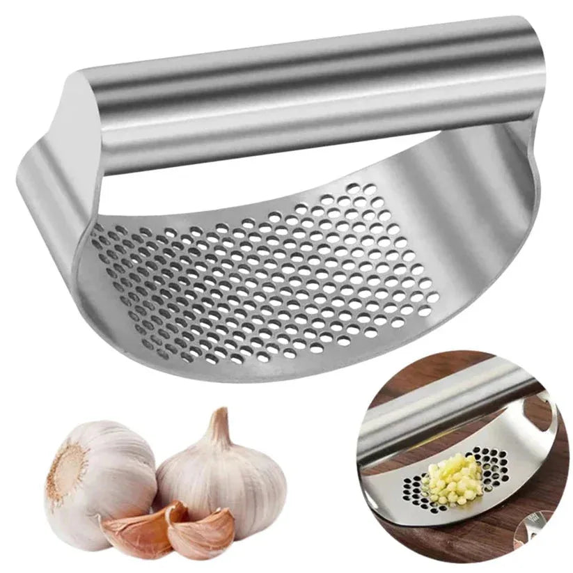 Stainless steel garlic press with garlic and crushed garlic on a white background

