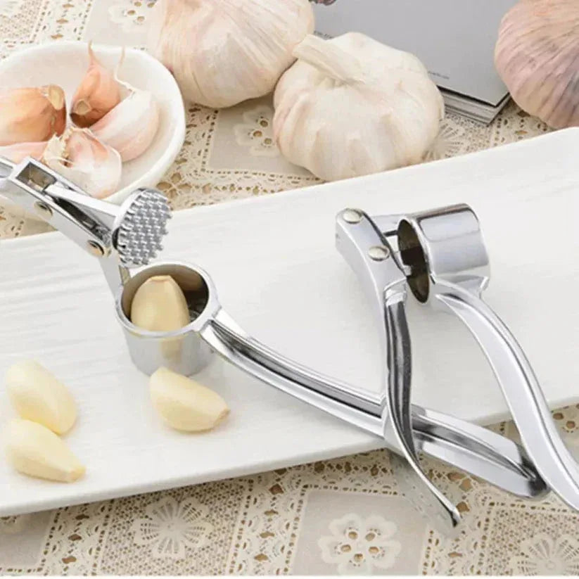 Garlic press with garlic cloves on a cutting board

