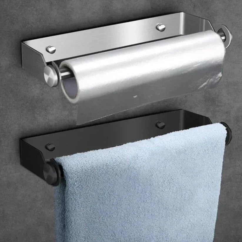 Metallic towel holder with a roll of paper towel on a gray wall.

